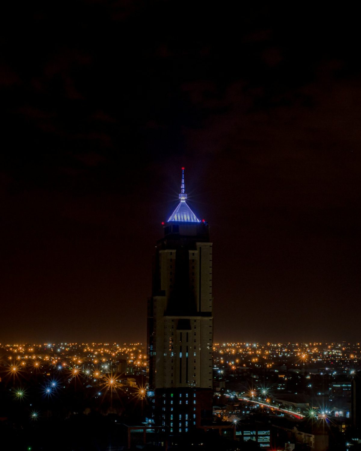 A lit tower above the Nairobi skyline at night